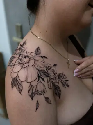 Tatuaż kwiatowy z piwoniami i pąkami na obojczyku i barku, czarne cieniowanie – tatuaż Zuzi, SHADY TATTOO Wieluń