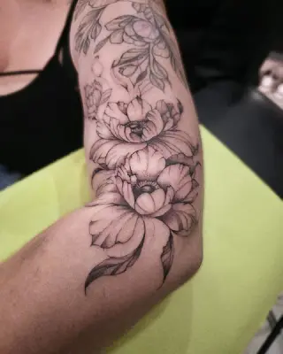 Dwie piwonie z liśćmi w czarno-szarym cieniowaniu na ramieniu – tatuaż Zuzi, SHADY TATTOO Wieluń